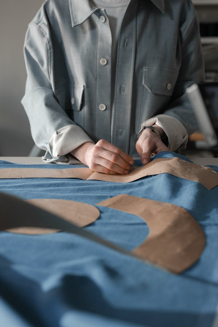 A fashion designer skillfully creating sewing patterns on fabric in a studio setting.